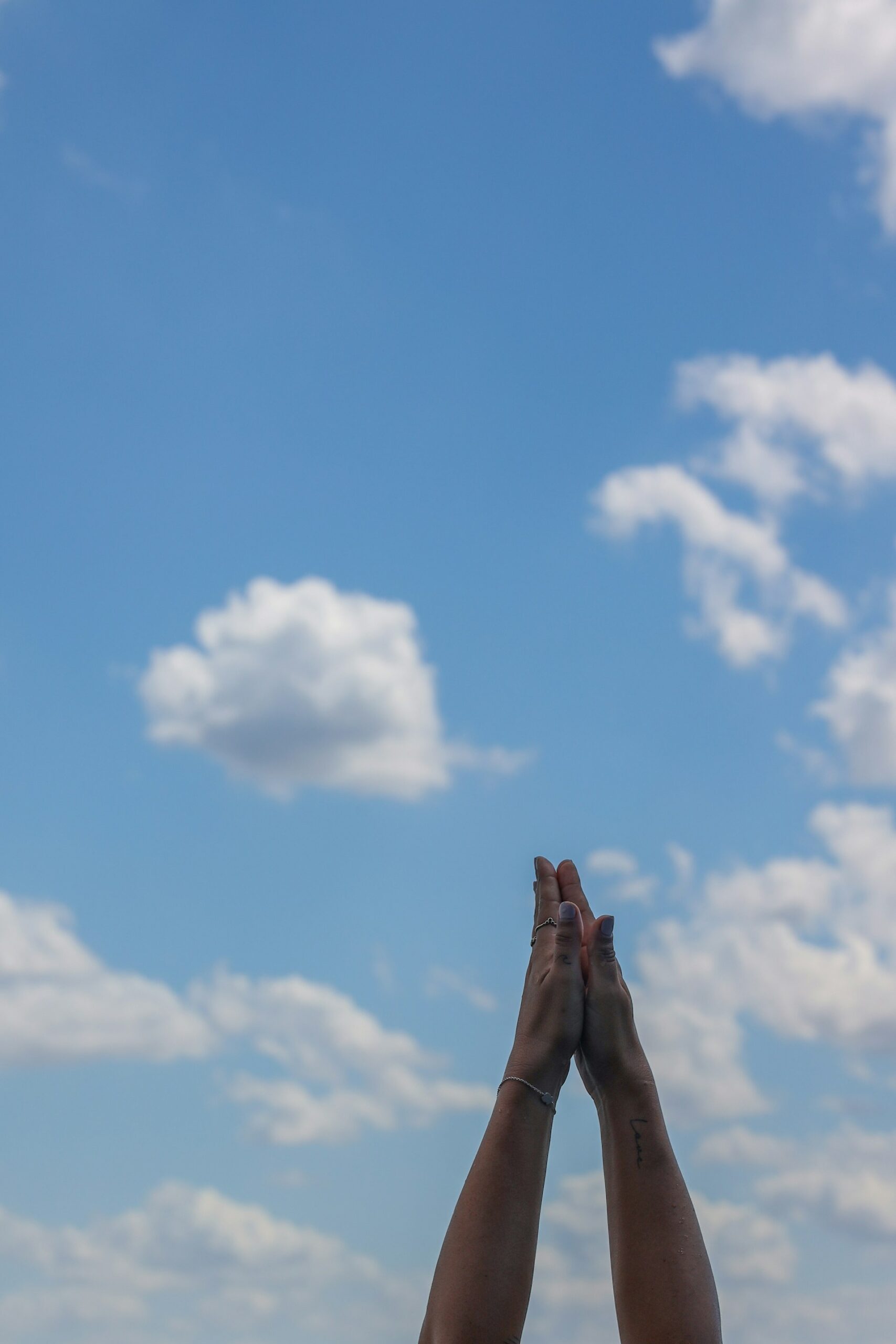 Hands folding and sky in background